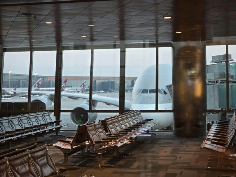 A passenger plane at Hamad International Airport in Doha with empty seating area in the foreground.